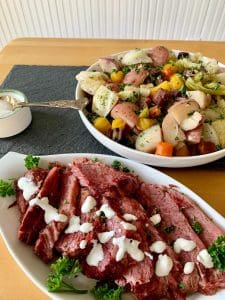 Corned beef on a platter with cabbage, potatoes and carrots