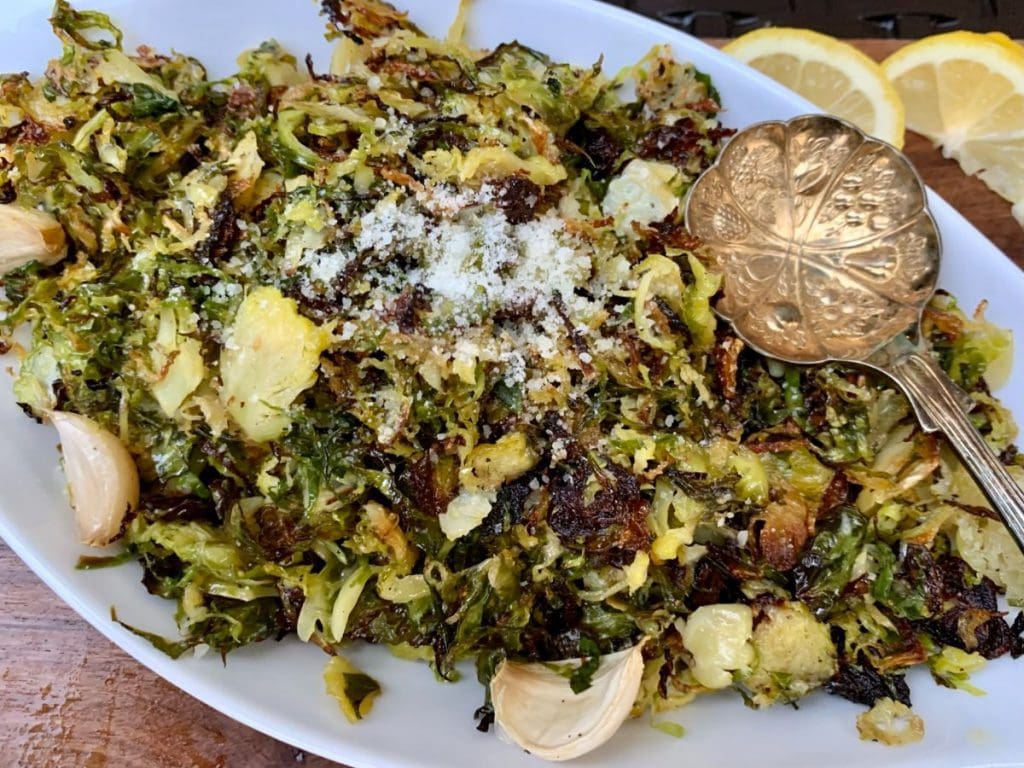 Roasted shaved Brussel sprouts in a serving dish and spoon