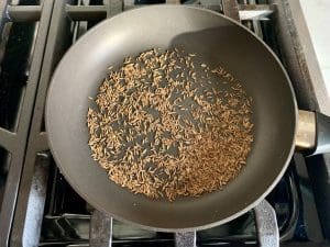 Toast cumin seeds in a skillet