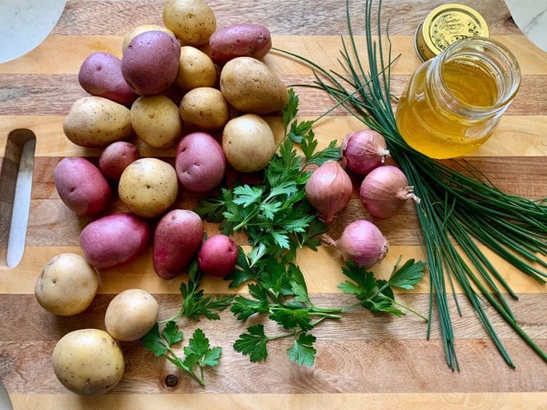 Ingredients for Warm Potato Salad on a cuttings board
