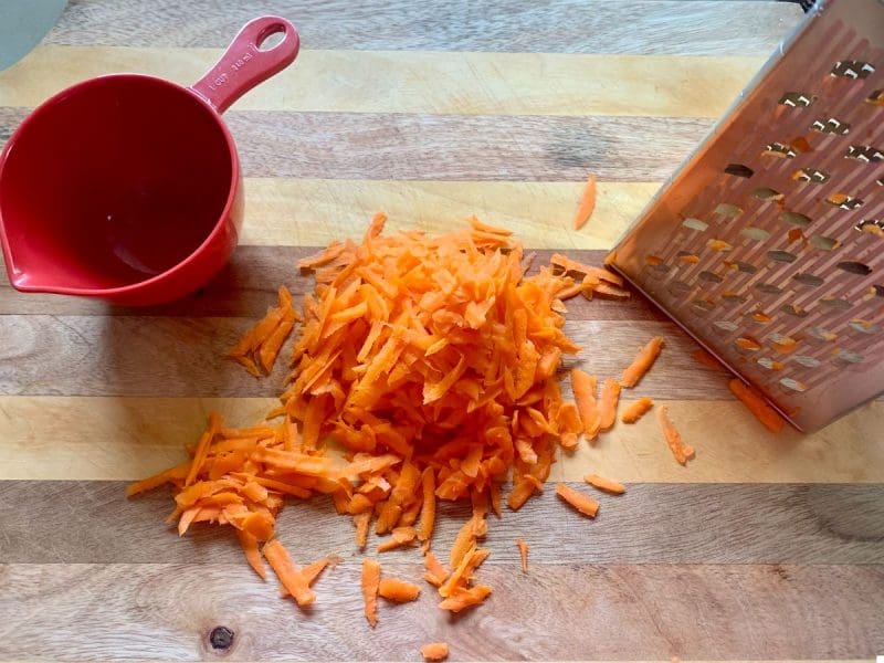 grate carrots for muffins batter with a box grater
