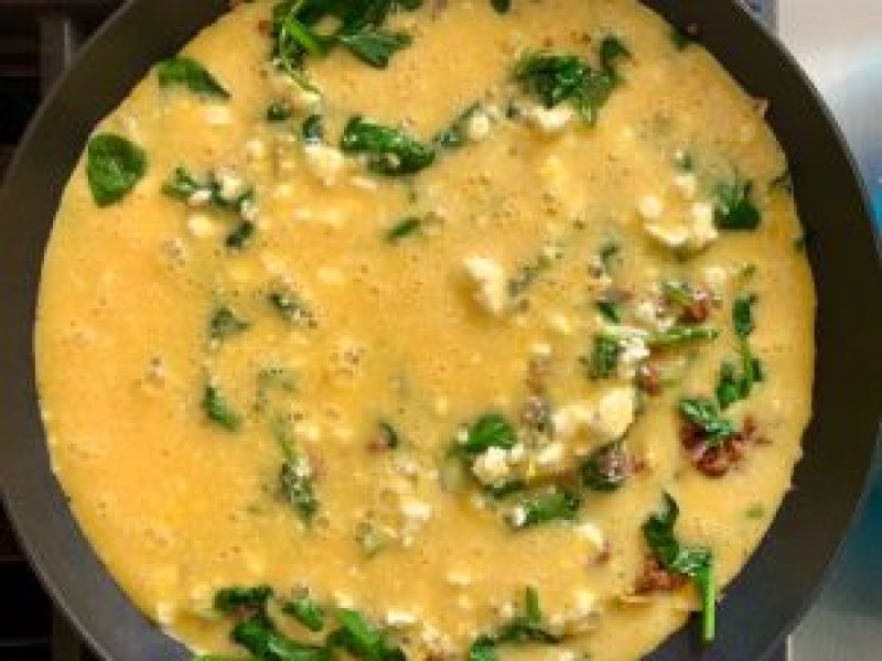 Frittata cooking on stovetop in non-stick skillet