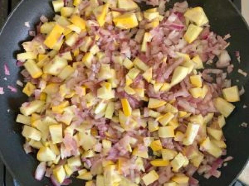 Saute onions and yellow squash in a non-stick pan