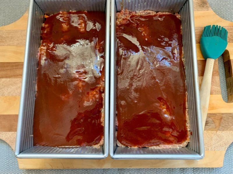 meatloaf in two loaf pans with BBQ sauce